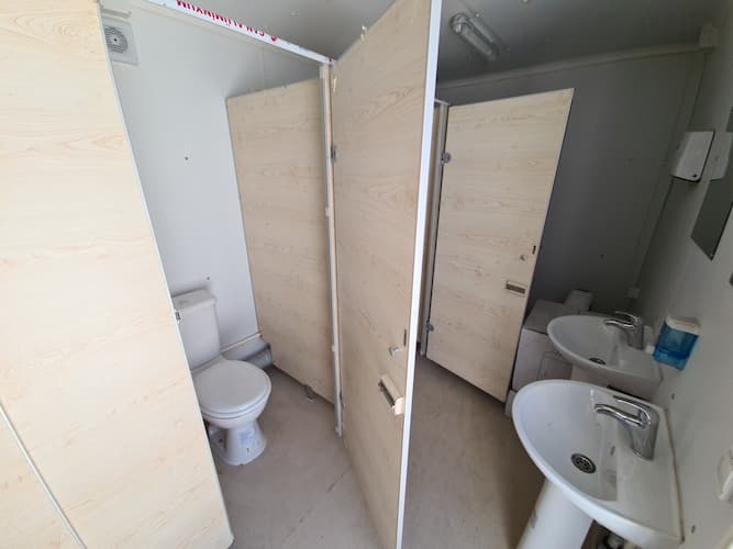 Konteinerinio tualeto vidus tualetai už durų, praustuvės ir veidrodžiai