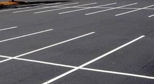 Dangos žymėjimo pavizdys asfalto aikštelė sužymėta baltomis automobilių stovėjimo kontūrų linijomis.